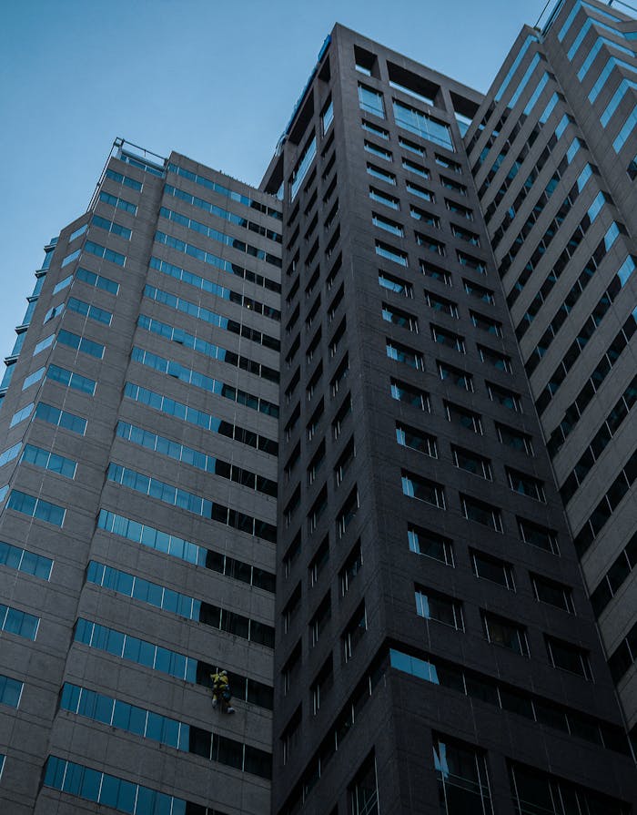 Low-angle view of a modern glass skyscraper in Cape Town, showcasing an architectural facade against a blue sky.